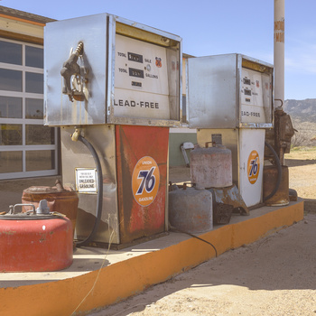 Vintage gas pump station with weathered metal panels and faded branding signage.