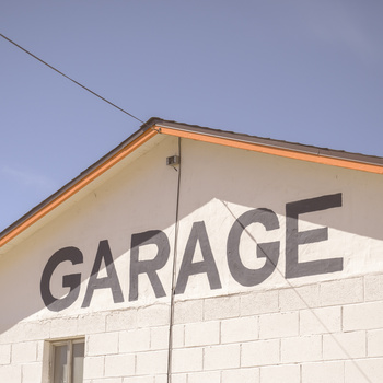 Large white building with bold black "GARAGE" text on its side wall.