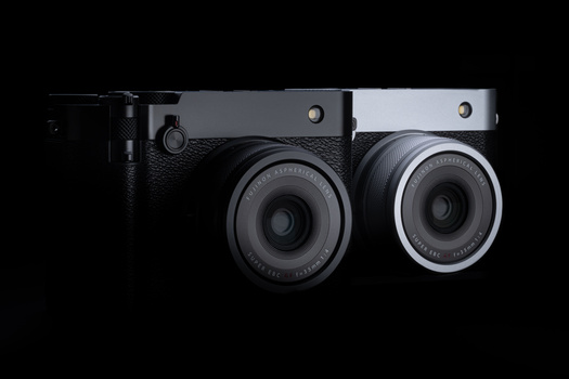 Two instant film cameras displayed side by side against a black background, showing black and silver body variants.