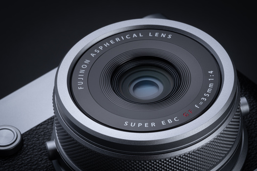 Fujinon Super EBC 23mm f/2 lens mounted on a camera body, shown at close range against a dark background.