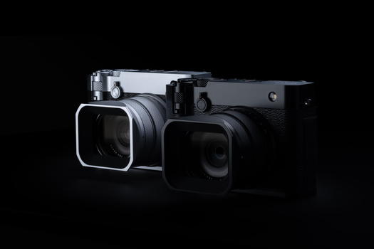 Two compact digital cameras with large square lens attachments positioned side by side against a black background.