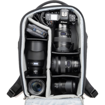 Camera backpack with organized compartments displaying Nikon camera body, telephoto and wide-angle lenses, and accessories.