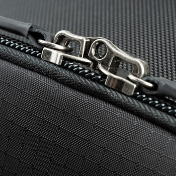 Close-up of a metal carabiner and stitched webbing strap on textured black fabric.