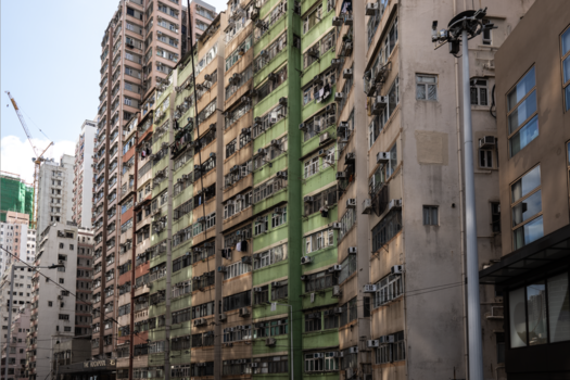 Dense cluster of aging residential high-rise buildings with weathered facades in various colors and states of repair.