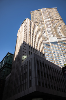 Three modern high-rise buildings photographed from ground level against clear blue sky.