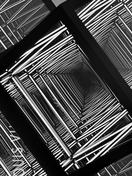 Overhead view of stacked wire storage baskets with strong geometric lines and shadows in black and white.