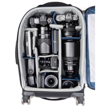 Open camera backpack displaying organized photography gear including multiple cameras, lenses, and accessories in padded compartments.