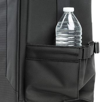 Water bottle secured in exterior pocket of dark gray camera backpack.