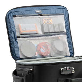 Open camera gear case with organized compartments containing photography equipment and cables.