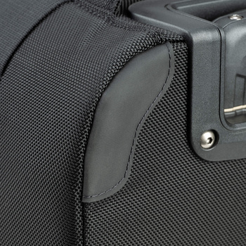 Close-up of camera bag material showing black mesh fabric and leather trim with metal hardware detail.
