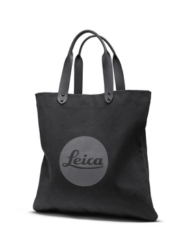 Black canvas tote bag with gray Leica circular logo and dual gray handles.