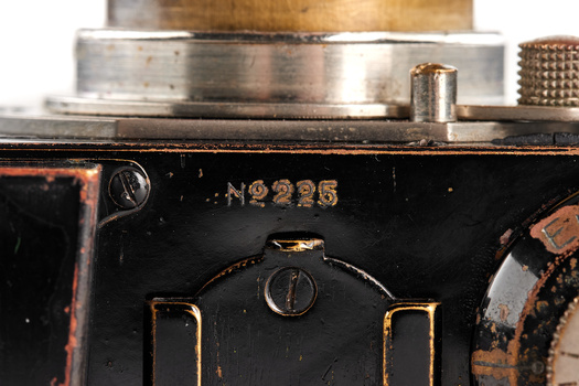 Close-up of vintage camera body showing serial number N2225 and mechanical shutter mechanism.