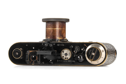 Top-down view of a vintage rangefinder camera with brown leather covering and brass fittings.
