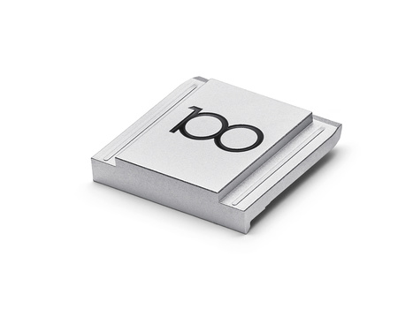 Stack of three printed books or portfolios with large number 100 on the top cover.