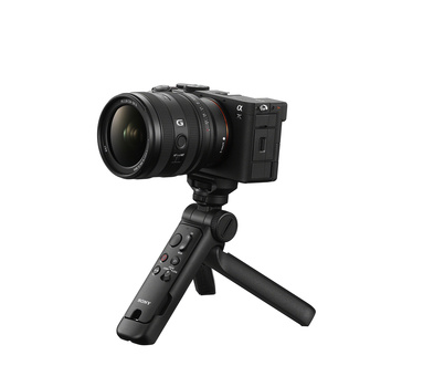Mirrorless camera with standard zoom lens mounted on a compact tripod grip with controls.