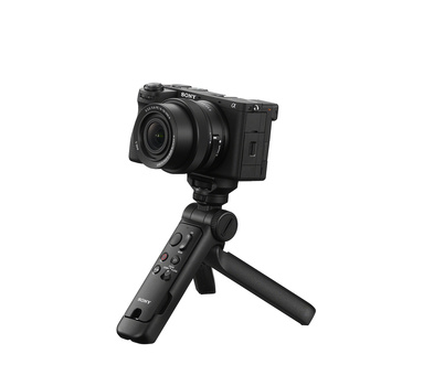 Compact mirrorless camera mounted on a handheld gimbal stabilizer with tripod legs.