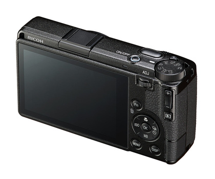 Compact digital camera viewed from rear angle showing LCD screen and control buttons.