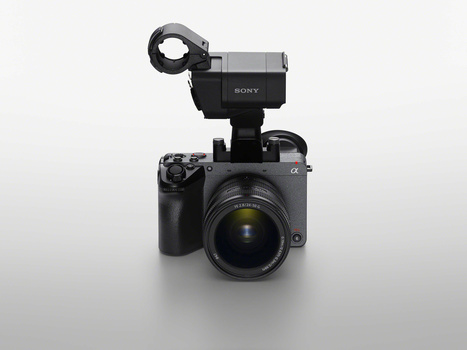 Sony mirrorless camera with mounted microphone on neutral gray backdrop.