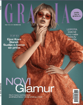 Magazine cover featuring woman in rust-colored dress and sunglasses against teal background.