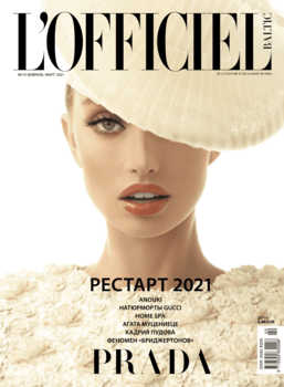 Fashion magazine cover featuring a model wearing a large cream-colored wide-brimmed hat against a neutral background.