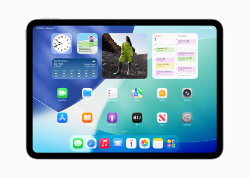 Screenshot of iPad home screen displaying widgets, apps, and a photo of a hiker on a mountain landscape.