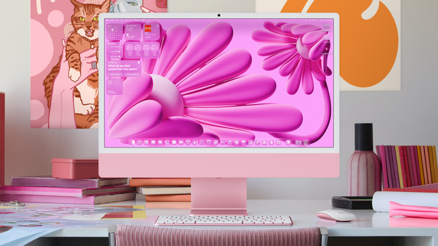Pink desktop setup with monitor displaying vibrant magenta abstract wallpaper and matching peripherals.