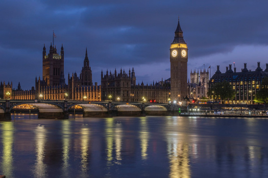 Westminster Palace and Big Ben illuminated at dusk across the River Thames, with Westminster Bridge in the foreground.