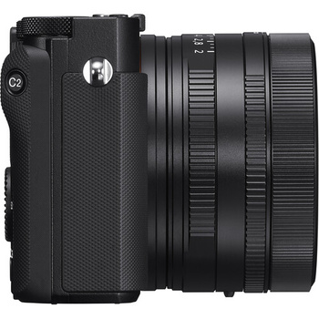 Black mirrorless camera with attached compact prime lens, shown from the side against a white background.