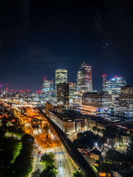 Illuminated downtown skyline at night with glowing streets and buildings creating an urban nightscape.