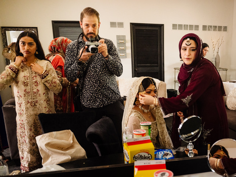 Five people in costume holding various props and objects in an indoor studio setting.