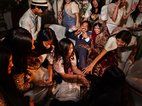 Group of people dancing together at an indoor celebration with warm ambient lighting.