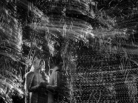 Two figures silhouetted against densely layered, scratched textures in high-contrast black and white.