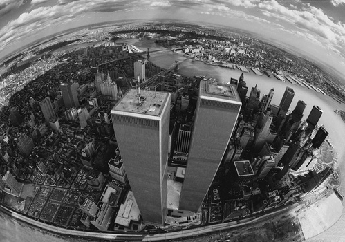 Aerial fisheye view of Manhattan's Twin Towers dominating the skyline surrounded by dense urban development.