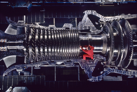Cross-sectional cutaway illustration of a multi-stage turbine engine with rotating blades and red rotor component.