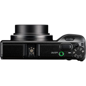 Top-down view of a compact digital camera with retractable lens and control dial.