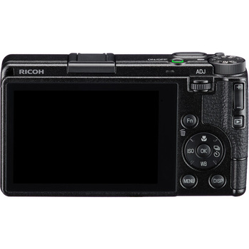 Ricoh compact digital camera shown from the rear, displaying LCD screen and control buttons.