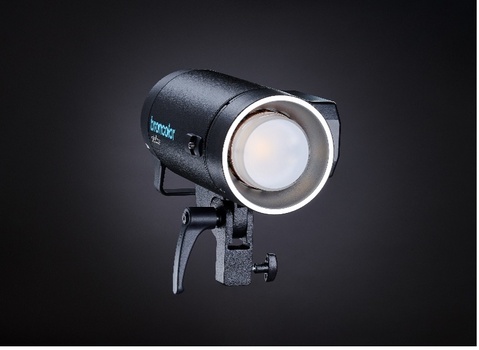 Professional studio monolight with reflector head and adjustment knobs mounted on stand.