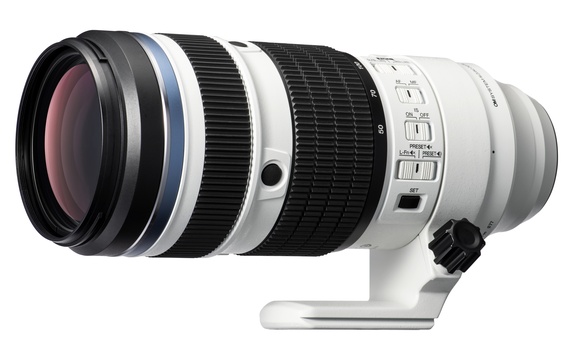 White and black telephoto lens with focus ring and tripod collar shown in profile against white background.