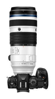 White telephoto zoom lens with black focus ring mounted on camera body shown from above.