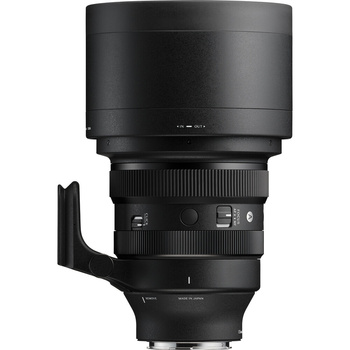 Black telephoto lens with hood and focus ring visible against white background.