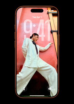 Man in light blue shirt and cream pants posed in dynamic martial arts stance on smartphone screen display.