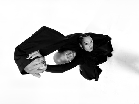 Three people in black clothing arranged in an overhead composition against a white background.