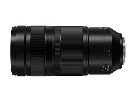 Black telephoto lens with multiple barrel sections and focus ring, photographed against white background.