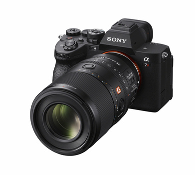 Sony Alpha mirrorless camera with telephoto lens attached, shown against white background.