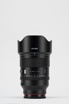 Viltrox lens with hood mounted, displayed against neutral gray background.