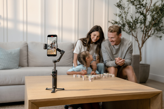 Content creator filming a family moment with a smartphone mounted on a stabilizer rig.