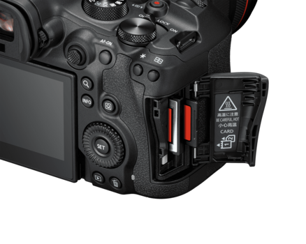 Professional cinema camera with open battery compartment showing two red batteries and internal components.