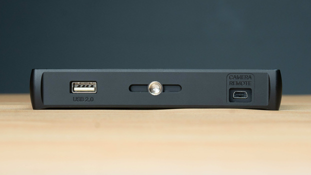Close-up view of a gray device's front panel showing USB 2.0 port, power button, and camera remote button.