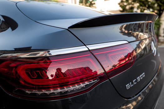 Close-up of a sedan's rear quarter panel showing red LED taillights and badging detail.