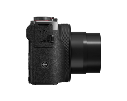Side view of a compact digital camera with textured black body and extended lens barrel.